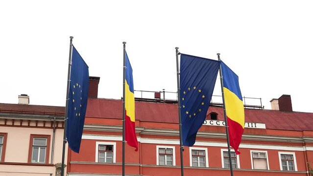 European Union and Romania flags waving in the wind. Economic and finance Community.