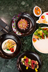 variety of restaurant food dishes on table. top view.
