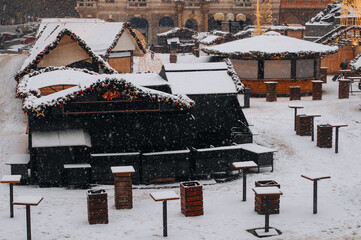 Closed stalls at a Christmas market early in the morning and lights.