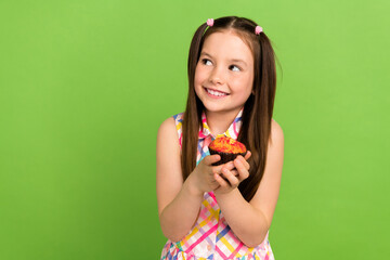 Photo of charming preteen age girl hansd hold fresh baked cake look empty space confection shop isolated on green color background
