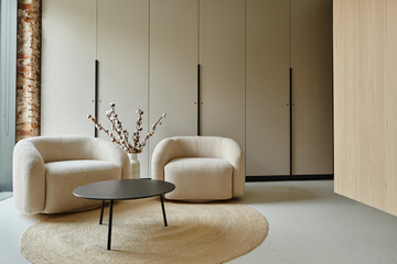 two comfortable white armchairs next to coffee table and cotton branches in vase, modern living room