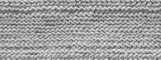 Seamless mottled light grey wool knit fabric background texture. Tileable monochrome greyscale knitted sweater, scarf or cozy winter socks pattern. Realistic woolen crochet textile craft