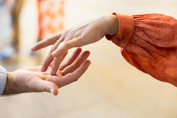Photo of two hands, one female and one male caressing each other.