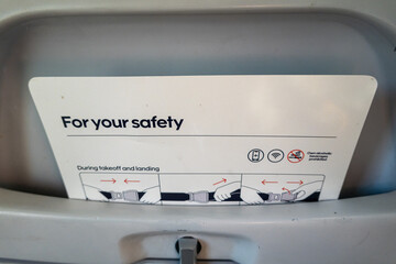 Stockholm, Sweden A safety brochure in the seat pocket of a commercial airliner. - obrazy, fototapety, plakaty