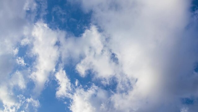 Timelapse of white clouds flowing in the afternoon blue sky