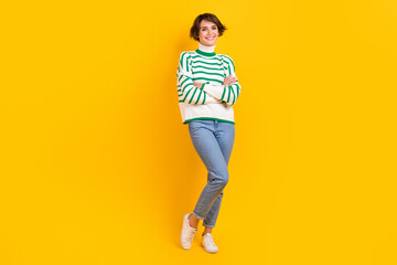 Fototapeta na wymiar Full body length photo of young charming lady wearing striped pullover jeans style folded arms posing model isolated on yellow background