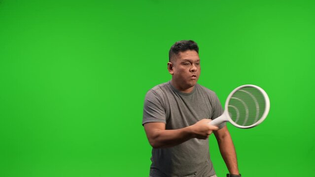 Middle aged asian man using electric bug zapper to kill flies and mosquitos on a green screen