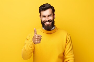 young man happily keeping thumbs up on isolated yellow background copy space