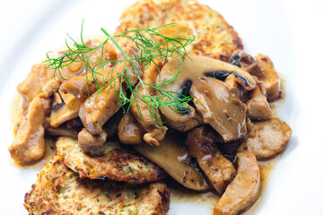 chicken meat with mushroom sauce served with potato pan cakes