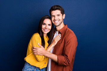 Portrait of two cheerful lovely people cuddle beaming smile care support concept isolated on blue color background
