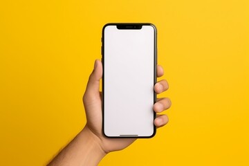 Closeup hand holding mobile phone mockup in yellow plain background