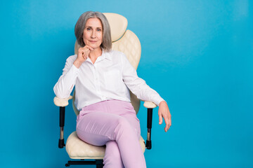Photo of pretty cute lady wear white shirt sitting chair arm hand chin empty space isolated blue...