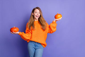Portrait astonished cheerful girl arms hold two pumpkins festive decor empty space isolated on purple color background