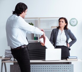 Old female boss and young male employee in the office