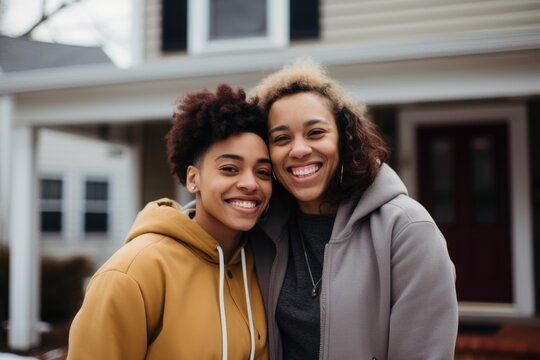 Smiling Portrait Of A Lesbian Couple In Front Of A House