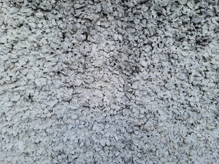 Rough concrete wall made of exposed aggregate pebbles and cement.Front view, full screen....