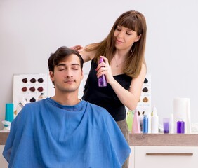 Young attracrive man visiting female barber