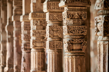 Stone columns with decorative bas relief of Qutb complex in South Delhi, India, close up pillars in...