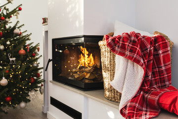 Interior of a modern living room with a burning fireplace, adorned with a Christmas decorations
