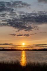 Orange summer sunset  with trees in silhouette at North Turtle Lake in Minnesota, USA
