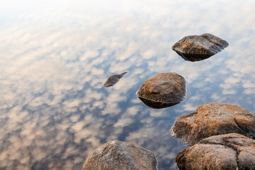 reflection of the sky and rock in the water