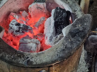 The charcoal stove that is lit is red.
