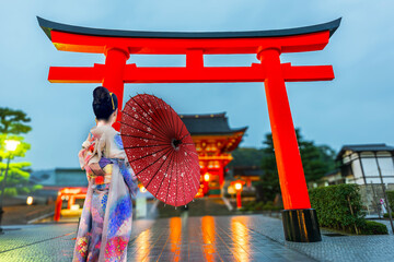 Young woman traveling at Fushimi Inari taisha Shrine at sunrise,  landmark and popular for tourists attractions in Kyoto,Japan.