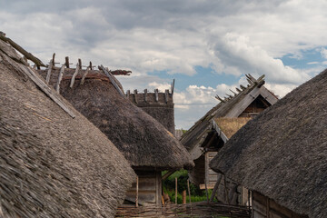 Traditional village with thatched roof and blue sky - obrazy, fototapety, plakaty
