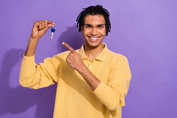 Photo of cheerful happy man wear trendy yellow clothes arm showing keys moving new flat isolated on...