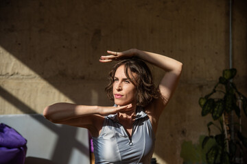 Fototapeta premium A girl dances a contemporary dance in a sunlit studio
