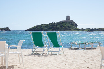 two unfolded beach chairs on the sand, a symbol of relaxation and rest, close up