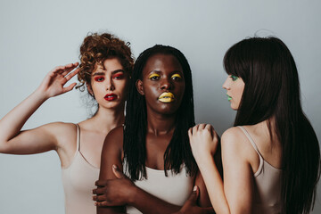 Three girls from different ethnicities posing in studio for a 