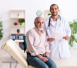 Fototapeta premium Old man visiting young male doctor cardiologist
