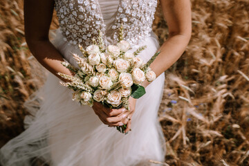 The bride is holding her wedding bouquet, a symbol of beauty and love, in her hands