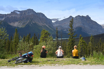 Cyclists rest in the mountains. Tourists in Banff National Park, Alberta, Canada. - obrazy, fototapety, plakaty