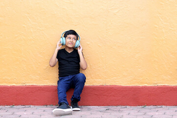 Brown Latino 9 year old boy with anti noise headphones for children with asperger syndrome, autism...