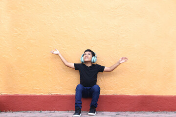 Brown Latino 9 year old boy with anti noise headphones for children with asperger syndrome, autism...