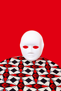 White mask on table near red wall