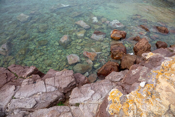 beautiful red stones sticking out of the water, sea embankment