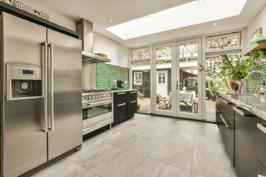 Kitchen with modern appliances and cabinet by window