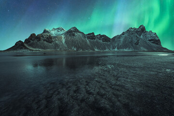 Water and mountain during northern lights