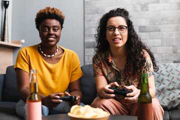 Two women play video games in the living room