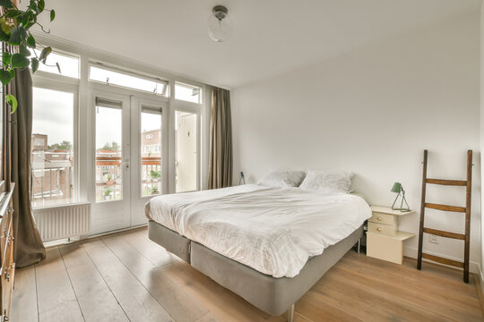 Bedroom with cozy white bed and large window