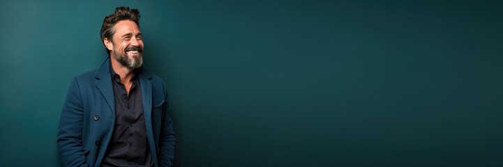 handsome middle aged man wearing casual clothes smiling to the side against a green blue background. Banner design with space for text