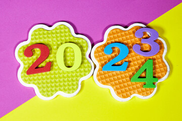 2024 New Year number. colorful sponge digits and design shaped saucer on colorfull background