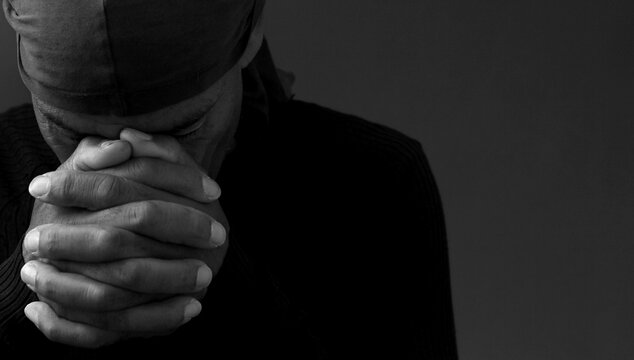 black man praying to god on gray background with people stock image stock photo