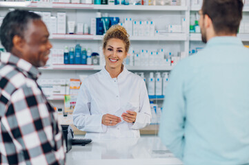 Woman pharmacist selling drugs to a senior patient customer in a pharmacy