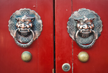 Beijing, China - April 3, 2013: Red door with dragon head door-knocker in hutong area, Beijing