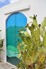  artistic door painted in sea colors, door in Ostuni, turquoise-blue door in a white wall, door for taking selfies