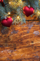 A festive Christmas garland with heart shaped ornaments on a rustic wooden backdrop - 661176707